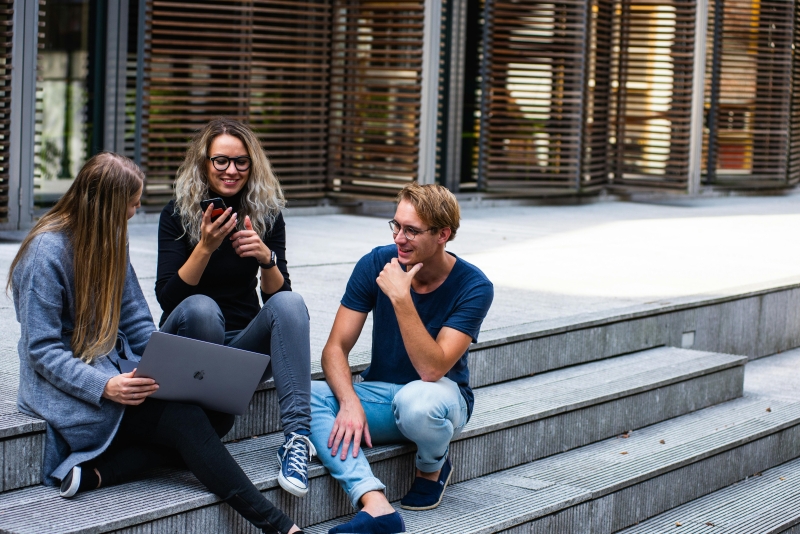 Tre studenter på en trappa.
